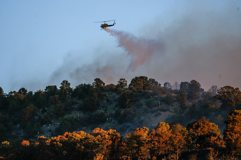 A helicopter drops water at the Sheep fire burnig in Wrightwood, Calif., Monday, June 13, 2022. (AP Photo/Ringo H.W. Chiu)