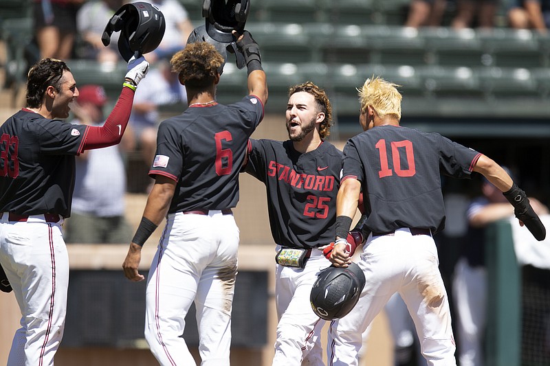 Stanford's Kody Huff (25) is congratulated by teammates Brett Barrera (33), Braden Montgomery (6) and Adam Crampton (10) after hitting a grand slam against Connecticut during the fourth inning of an NCAA college baseball tournament super regional game, Monday, June 13, 2022, in Stanford, Calif. (AP Photo/D. Ross Cameron)