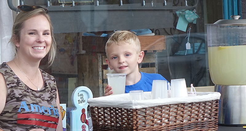 Lemonade, of course. Just the thing for a Saturday outdoor community market. That’s Landon Rowell, 6, with the help of mom, Carly Rowell, serving the drink. (photo by Neil Abeles)