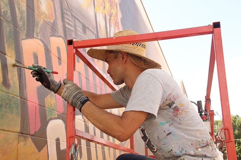 LYNN KUTTER ENTERPRISE-LEADER
Lucas Aoki, a native of Argentina, paints a mural at Prairie Grove Public Library last week. He has lived in the Austin, Texas, area since 2007.