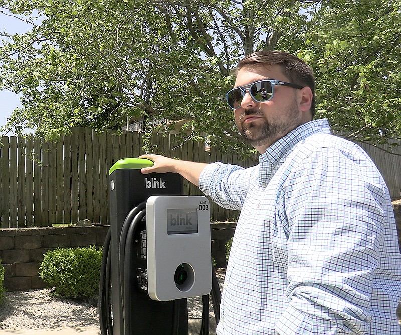 EV Charging Solutions CEO Skylar Keller shows off his Blink charging station Tuesday at Baymont by Wyndham Hot Springs On the Lake. - Photo by Donald Cross of The Sentinel-Record