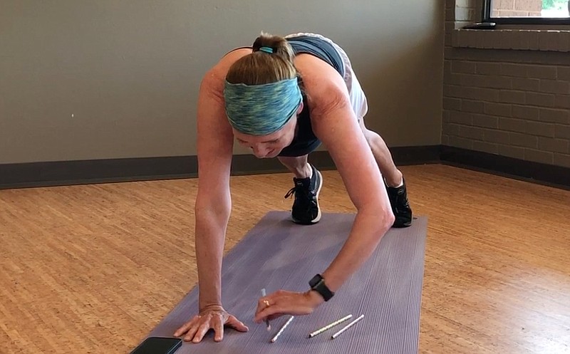 Trish Blair picks up pencils while doing planks -- a Master Class exercise that's fun to do with a group exercise class.  (Arkansas Democrat-Gazette/Celia Storey)