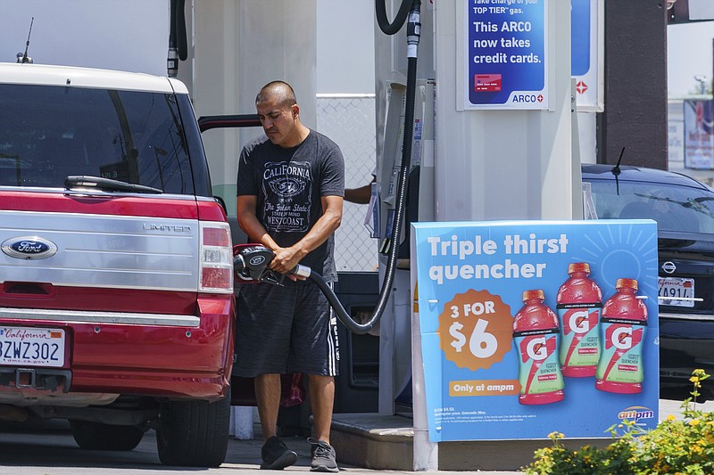 A motorist pumps gasoline at an ARCO gas station in Los Angeles, Sunday, June 12, 2022. Soaring gasoline prices have left many consumers with no choice but to cut spending on non-essentials, but it might be coming full circle by stopping some drivers from filling up their tanks. (AP Photo/Damian Dovarganes, File)
