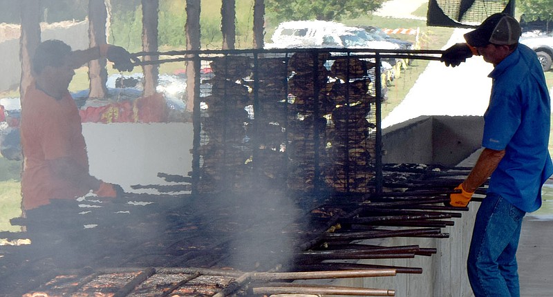 A pair of chicken flippers rotate a rack of chicken halves Aug. 7, 2021, during the 67th Decatur Barbecue at Veterans Park in Decatur.
(File Photo/NWA Democrat-Gazette/Mike Eckels)