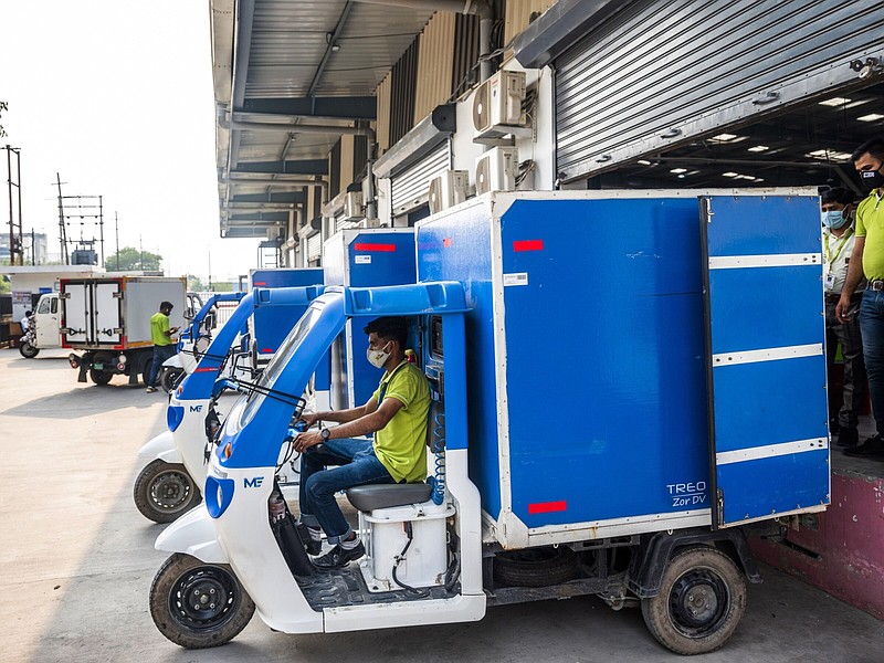A delivery rider in a Mahindra Treo Zor electric vehicle departs a loading bay at a BigBasket warehouse in Noida, Uttar Pradesh, India. MUST CREDIT: Bloomberg photo by Prashanth Vishwanathan.