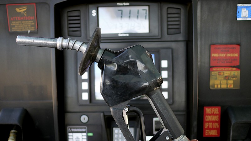 A gasoline pump is shown at a gas station Friday, June 10, 2022, in Salt Lake City.  With record-high gas prices, travelers can save money on summer road trips by considering alternatives. They can plan a trip to U.S. regions with lower-cost fuel, like the Midwest or South. If travelers need to rent a car, they might find affordable options by going to a cheaper car rental location or considering a car rental alternative like car sharing. With more hotels offering electric vehicle charging, renting an electric car could be more convenient and less expensive than expected. No matter what car or region, spending on a rewards credit card, particularly one that earns extra points on gas, could help lessen the sting of road trip expenses.(AP Photo/Rick Bowmer, File)