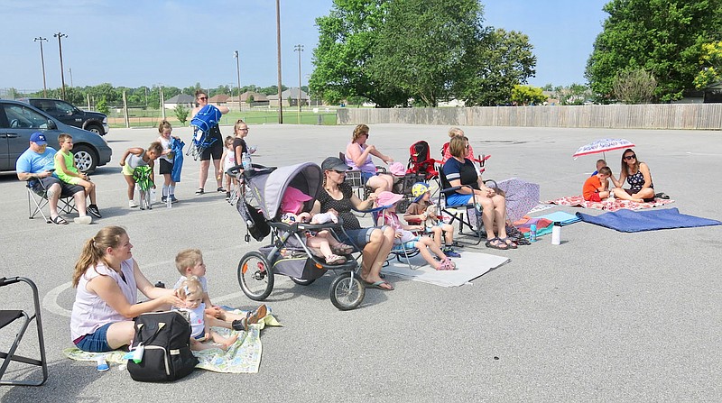Westside Eagle Observer/SUSAN HOLLAND
Several parents spread blankets and quilts in the parking lot of Pop Allum Park Thursday morning, June 16, as they and their children prepared to watch the Trike Theatre production of "Mariposa Butterfly." The bilingual play, sponsored by the Gravette Public Library, focused on the differences between two neighbors and how the life cycle of a mariposa butterfly which visits both their gardens brings them together.