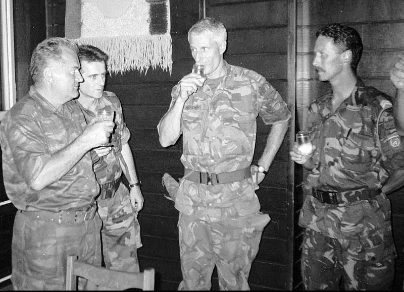 FILE - Bosnian Serb army Commander General Ratko Mladic, left, drinks with Dutch U.N Commander Tom Karremans, second right, while others unidentified look on, in Potocari, some 5 kilometers (3 miles) north of Srebrenica,  Bosnia, July 12, 1995. The Dutch government formally apologized Saturday, June 18, 2022 to soldiers who were sent as United Nations peacekeepers to defend the Bosnian enclave of Srebrenica with insufficient firepower and manpower to keep the peace. (AP Photo, File)