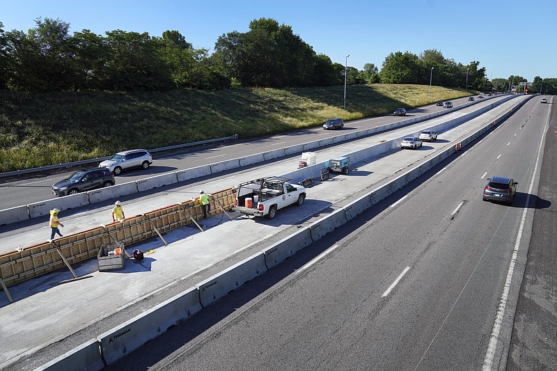 Traffic flows past workers in a construction zone along Interstate 55 Thursday, June 9, 2022, in St. Louis. The Missouri Department of Transportation is doing a series improvement projects along Interstate 55 but inflation has pushed up the cost. (AP Photo/Jeff Roberson)