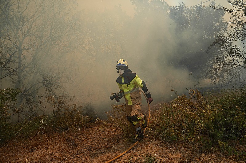 A firefighter works in the San Martin de Unx area in northern Spain, Sunday, June 19, 2022. Firefighters in Spain are struggling to contain wildfires in several parts of the country which as been suffering an unusual heat wave for this time of the year. (AP Photo/Miguel Oses)