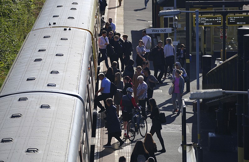 Passengers board a train at Hunts Cross Station, in Liverpool, England, Monday, June 20, 2022. Unions and train companies in Britain are set to hold last-minute talks Monday amid fading hopes of averting the country&#x2019;s biggest rail strikes for decades. (Peter Byrne/PA via AP)