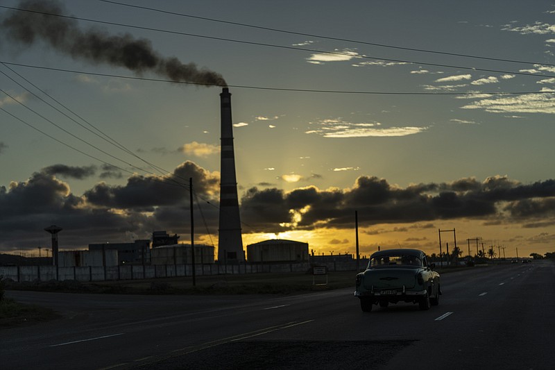 Un automóvil estadounidense antiguo pasa frente a la central eléctrica Ernesto Guevara en Santa Cruz del Norte, Mayabeque, Cuba, el domingo 17 de abril de 2022. (Foto AP/Ramón Espinosa)
