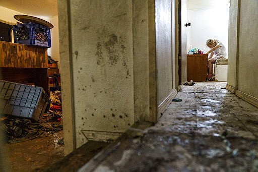 Harley Holmes, de 8 años, limpia su habitación mientras su familia es obligada a evacuar su casa dañada por las inundaciones, el viernes 17 de junio en Fromberg, Montana. (AP Foto/David Goldman)