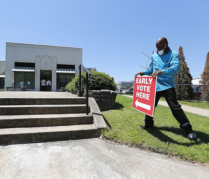 Poll worker Ron Dangerfield adjusts a voting sign that had fallen down outside the Pulaski County Regional Building on Monday, June 20, 2022, in Little Rock. Monday was the final day of early voting in the state. 
(Arkansas Democrat-Gazette/Thomas Metthe)