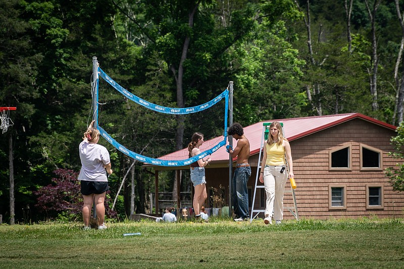 (Left to right) Staff members Julia Robinson, Madelyn Conwell, and Julian Sarin, and operations manager Mikayla Butz-Weidner, put up a volleyball net at Camp Galil. (Jessica Griffin/Philadelphia Inquirer/TNS)