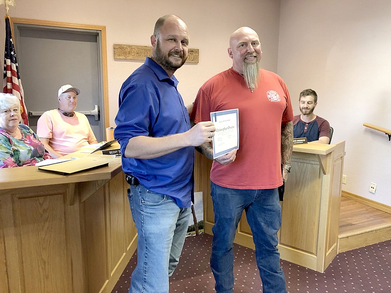 RACHEL DICKERSON/MCDONALD COUNTY PRESS Paul Buckner, left, presents Pineville Marshal Chris Owens with a certificate in recognition of talking a man with a knife out of "suicide by cop."