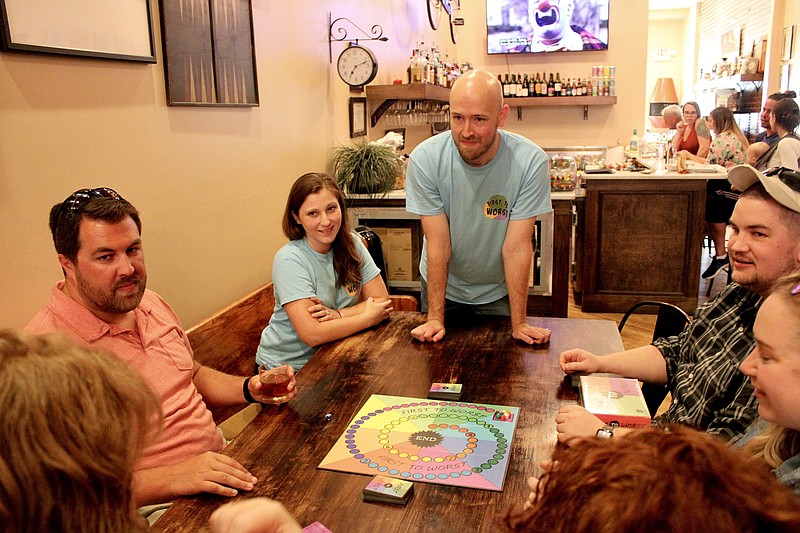 Clayton Toebben, center, walks players through his board game "First to Worst" at Cork & Board during its first "Meet the Gamemaker" event on June 22, 2022. (News Tribune/Cameron Gerber)