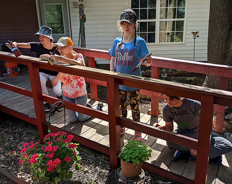 Westside Eagle Observer/RANDY MOLL
Jaxon Reed, Kenzie Kilgore, Allyson Hayes and Jonah Tunage-Hoang, volunteers for the Ozark Mission Project, painted a wheelchair ramp in rural Gentry on Thursday. The work was done at no cost to the resident.