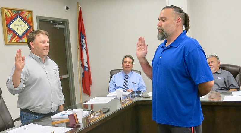 Westside Eagle Observer/SUSAN HOLLAND
Gravette mayor Kurt Maddox (left) swears in David Henzie as the new city clerk/treasurer at the city council meeting Thursday, June 23. Henzie, who owns and operates Henzie's Art Studio, replaces Dani Madison, who moved outside the city limits and is no longer eligible to serve. Pictured in the background are city attorney David Bailey and council chair Richard Carver.