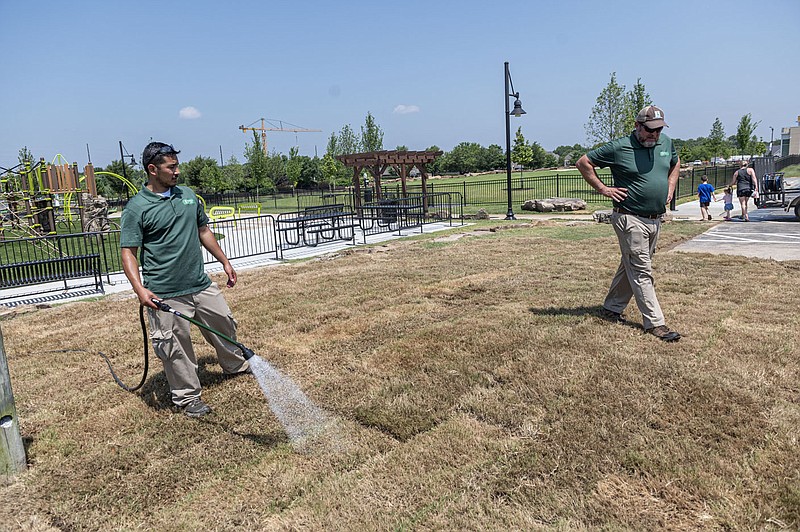 Chris Floes, left, and Creek Wenger (CQ) work Friday June 24, 2022 to get the Orchards Playground and dog park in Bentonville ready to open today with a celebration from 10 a.m. to 1 p.m.
(NWA Democrat-Gazette/Spencer Tirey)