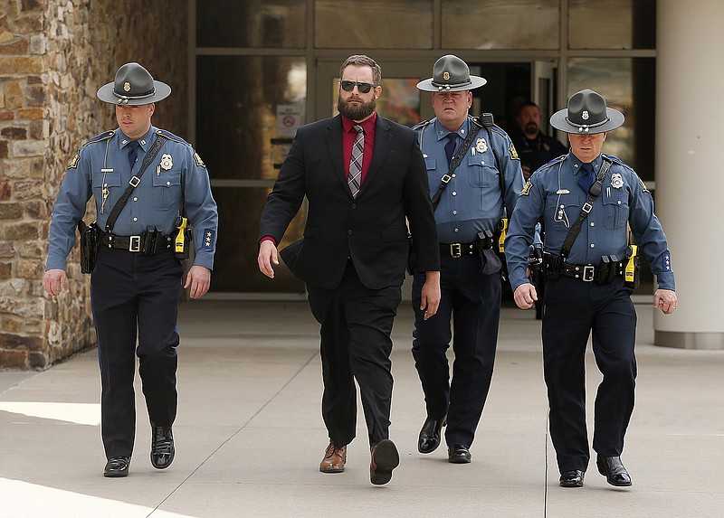 FILE - Arkansas State Troopers escort former Lonoke County sheriff's deputy Michael Davis, left center, after being convicted of negligent homicide on Friday, March 18, 2022, at the Cabot Readiness Center in Cabot, Ark. The family of an unarmed Arkansas teenager fatally shot during a traffic stop filed a federal lawsuit Thursday, June 23, 2022, against the former deputy who killed him. The lawsuit also names Lonoke County Sheriff John Staley. (Thomas Metthe/The Arkansas Democrat-Gazette via AP, File)