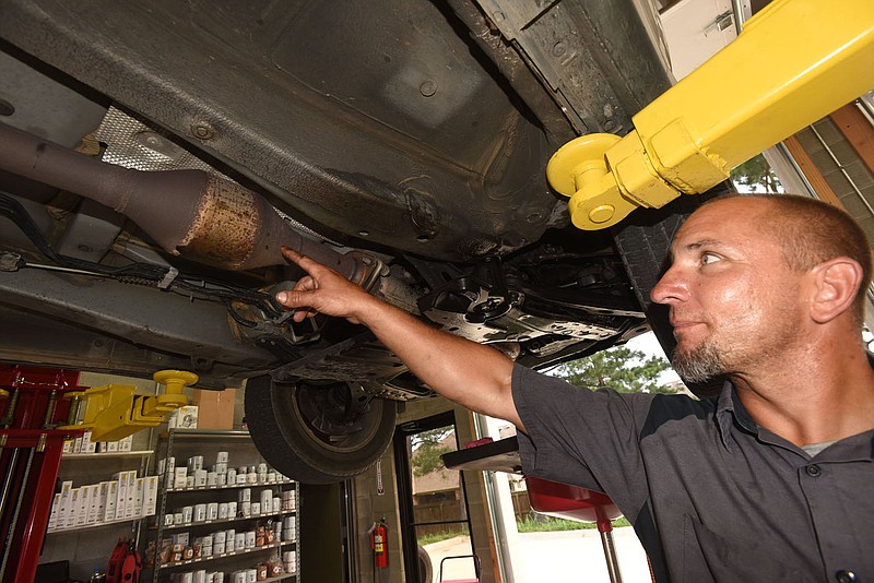 Howard Allen, a technician at Straightline Automotive in Centerton, shows on Wednesday June 22 2022 the catalytic converter on a Lexus RX 350. The devices reduce toxic emissions in vehicle exhaust.
(NWA Democrat-Gazette/Flip Putthoff)
