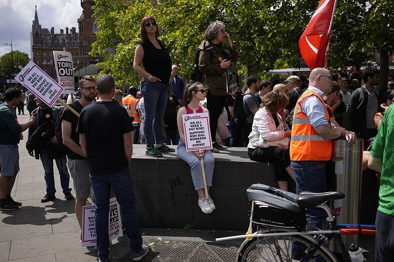 People holds placards as they attend a RMT (The National Union of Rail, Maritime and Transport Workers) union train strike rally outside King's Cross railway station, in London, Saturday, June 25, 2022. Some train stations were all but deserted across Britain on Saturday, as the third day of a national strike snarled the weekend plans of millions. Train companies said only a fifth of passenger services would run, as about 40,000 cleaners, signalers, maintenance workers and station staff walked off the job in Britain's biggest and most disruptive railway strike for 30 years. (AP Photo/Matt Dunham)