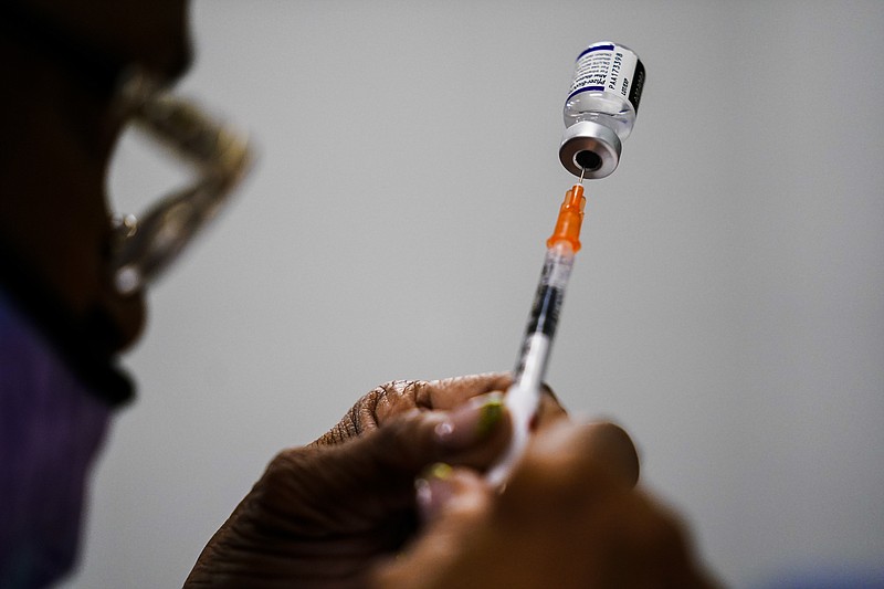 FILE - A syringe is prepared with the Pfizer COVID-19 vaccine at a vaccination clinic at the Keystone First Wellness Center in Chester, Pa., Dec. 15, 2021.  Pfizer says tweaking its COVID-19 vaccine to better target the omicron variant is safe and boosts protection. Saturday, June 25, 2022 announcement comes just days before regulators debate whether to offer Americans updated booster shots this fall. (AP Photo/Matt Rourke, File)