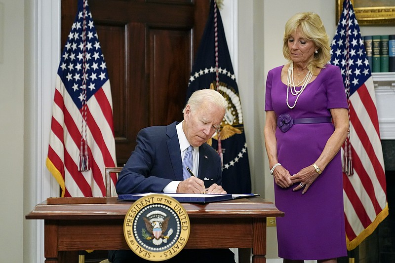President Joe Biden signs into law S. 2938, the Bipartisan Safer Communities Act gun safety bill, in the Roosevelt Room of the White House in Washington, Saturday, June 25, 2022. First lady Jill Biden looks on at right. (AP Photo/Pablo Martinez Monsivais)