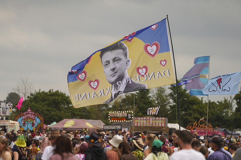 A flag with the image of Ukrainian President Volodymyr Zelenskyy and the words 'Dance For Ukraine' is seen at the Glastonbury Festival in Worthy Farm, Somerset, England, Friday, June 24, 2022. (AP Photo/Scott Garfitt)
