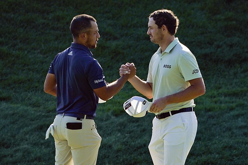 Xander Schauffele, left, and Patrick Cantlay shake hands after finishing Saturday's third round of the Travelers Championship at TPC River Highlands in Cromwell, Conn. Schauffele holds a one-stroke lead ahead of Cantley heading into the final round. (Associated Press)