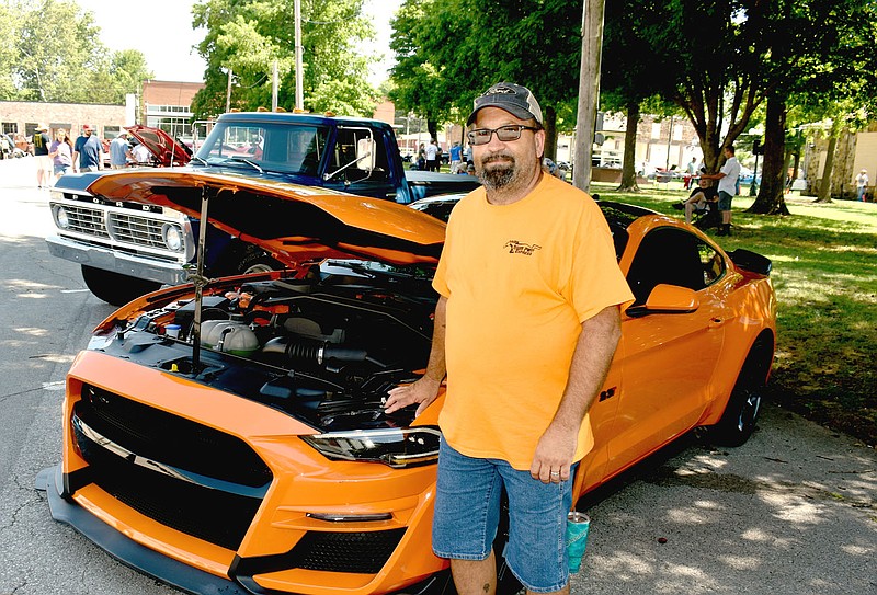 MARK HUMPHREY ENTERPRISE-LEADER/Stacey Cawyer, of Farmington, brought his 2020 Ford Mustang to the 11th annual Chicken Rod Nationals held at the Lincoln Square on Saturday. He bought the car as a stock model last year because “it almost looked custom,” featuring a factory stock color “Twister Orange” with a black roof that sets it apart. This was Cawyer’s second car show. He competed in May at Rogers when the “Hot Wheels Legends” came through.