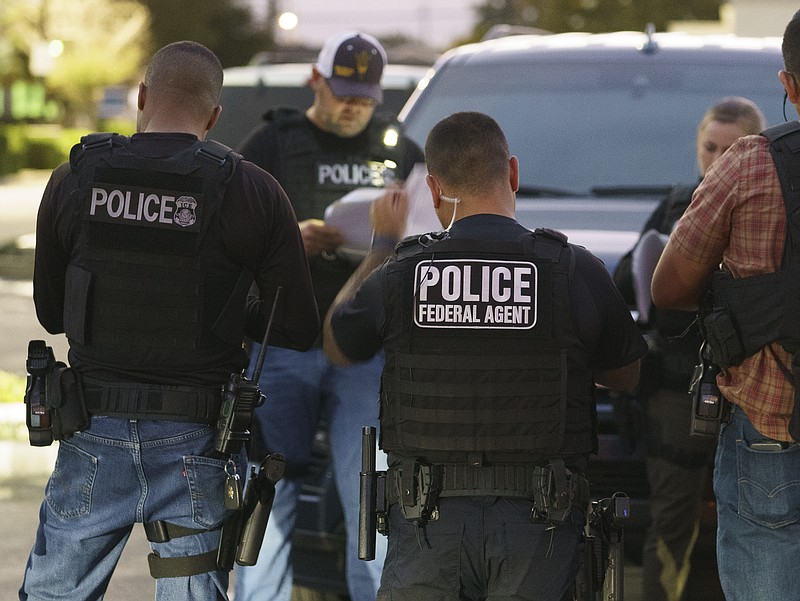 Agentes del Servicio de Control de Inmigración y Aduanas se reúnen antes de una redada para arrestar a inmigrantes considerados una amenaza a la seguridad pública y nacional, el lunes 6 de junio de 2022, en Compton, California. (AP Foto/Damian Dovarganes)