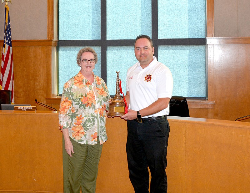 Marc Hayot/Siloam Sunday Siloam Springs Fire Chief Jeremey Criner receives the Fire Chief of the Year award from Mayor Judy Nation during the city board meeting on June 21.