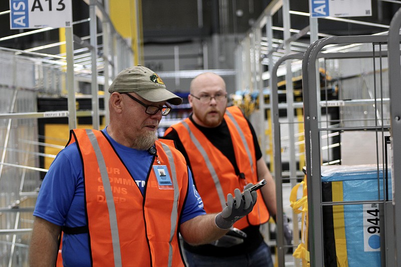 Cameron Gerber/News Tribune
Employees sort packages Thursday at the new Amazon delivery station in Ashland.