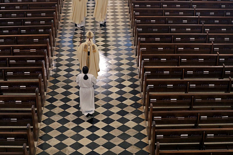 FILE - Archbishop Gregory Aymond conducts the procession to lead a live streamed Easter Mass in St. Louis Cathedral in New Orleans, Sunday, April 12, 2020. The FBI has opened a widening investigation into Roman Catholic sex abuse in New Orleans, looking specifically at whether priests took children across state lines to molest them. The FBI declined to comment, as did the Louisiana State Police, which is assisting in the inquiry. The Archdiocese of New Orleans declined to discuss the federal investigation.  “I’d prefer not to pursue this conversation,”  Aymond told AP. (AP Photo/Gerald Herbert, File)