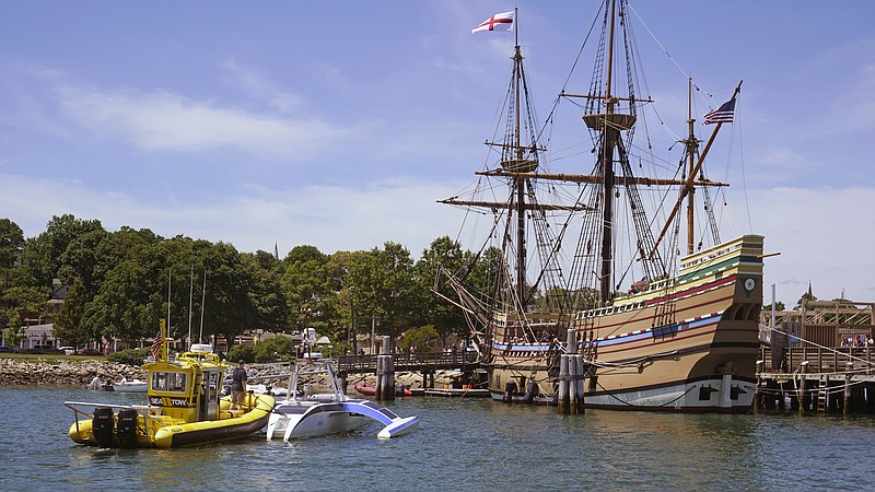 Brett Phaneuf, co-director of the Mayflower Autonomous Ship project, at left, stands on the deck of a tow boat as the Mayflower Autonomous Ship is guided next to the replica of the original Mayflower, Thursday, June 30, 2022, in Plymouth, Mass. The crewless robotic boat retraced the 1620 sea voyage of the Mayflower. (AP Photo/Charles Krupa)