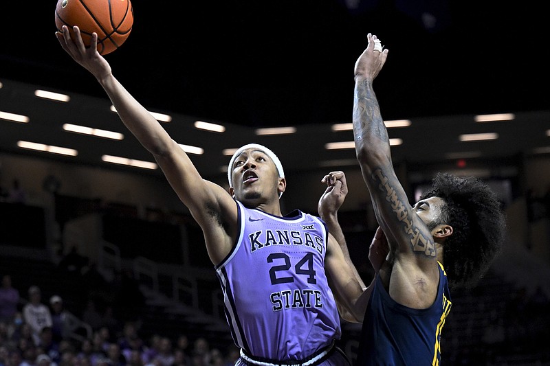 FILE - Kansas State guard Nijel Pack (24) shoots next to West Virginia forward Isaiah Cottrell during an NCAA college basketball game in Manhattan, Kan., Feb. 14, 2022. The first year of the athlete compensation era in college sports evolved into almost everything the NCAA didn't want when it gave the green light last summer.
What originally was envisioned as a way for college athletes to make some pocket money based on their celebrity has turned into bidding wars for football and men's basketball recruits and transfers. Pack made one of the first big splashes in April. (AP Photo/Reed Hoffmann, File)