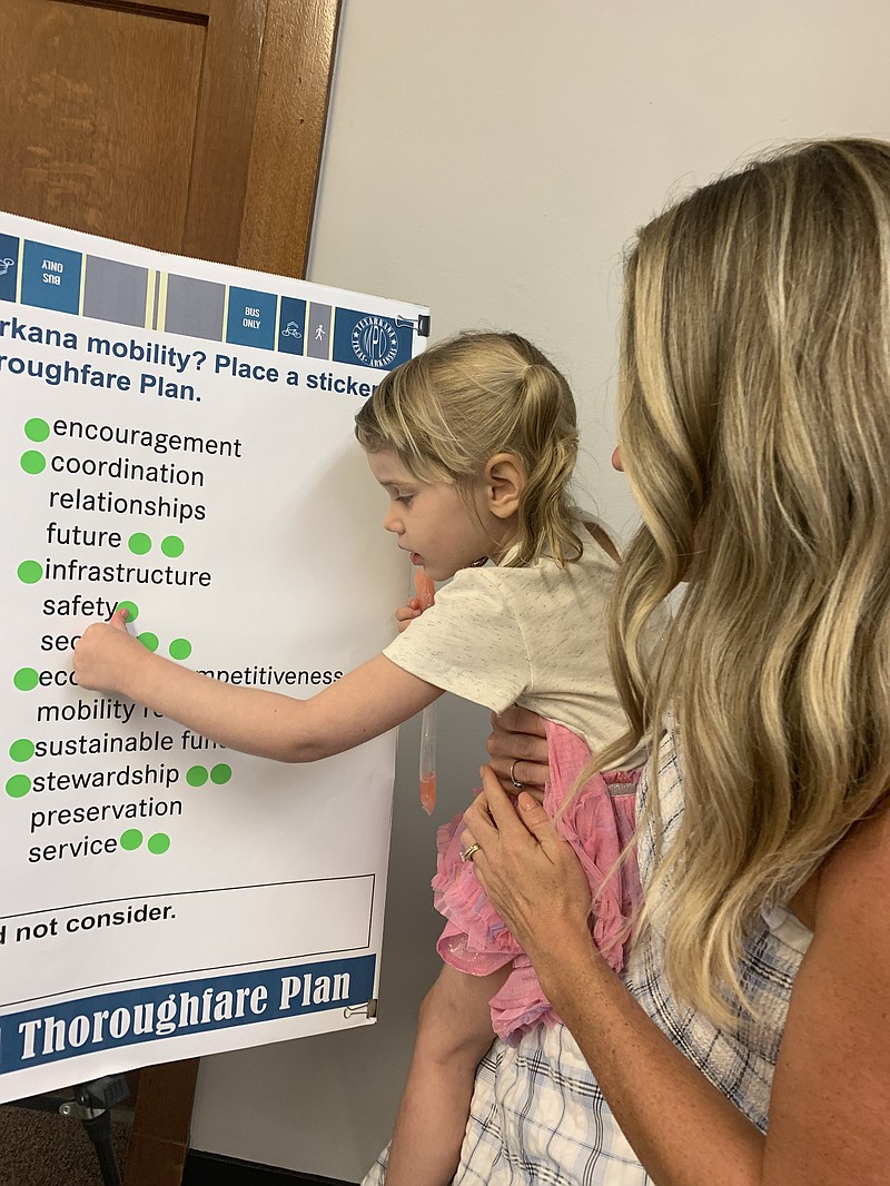 Rebecca Fite helps her daughter Pamela put a sticker next to safety on a poster board at the transportation open house Wednesday, June 29, 2022, at Texarkana, Texas, City Hall. (Staff photo by Mallory Wyatt)