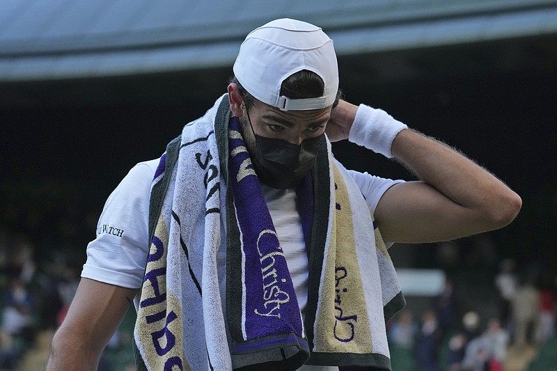 FILE - Italy's Matteo Berrettini wears a mask at the end of the third set during the men's singles quarterfinals match against Canada's Felix Auger-Aliassime on day nine of the Wimbledon Tennis Championships in London, Wednesday, July 7, 2021. At Wimbledon, where the All England Club is following British government COVID guidance that requires neither shots nor testing, three of the top 20 seeded men have withdrawn over the first four days of action because they got COVID-19, with No. 17 Roberto Bautista Agut pulling out Thursday, June 30, 2022. (AP Photo/Alberto Pezzali, File)