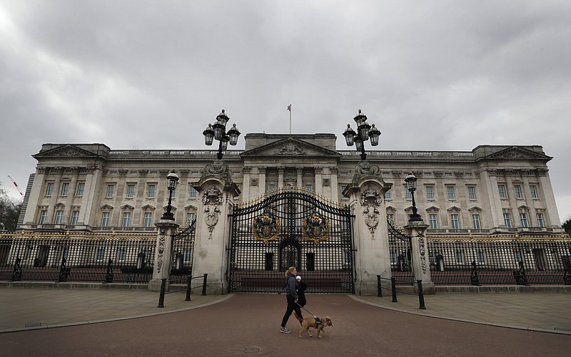 ARCHIVO – Una mujer camina con un perro y un bebé frente al Palacio de Buckingham el 23 de marzo de 2021. El gasto del presupuesto público de la monarquía británica aumentó 17% a 102,4 millones de libras esterlinas (124 millones de dólares) en el último año, de los cuales la renovación del Palacio de Buckingham requirió una gran cantidad, según un reporte publicado el jueves 30 de junio de 2022. (Foto AP/Kirsty Wigglesworth, archivo)