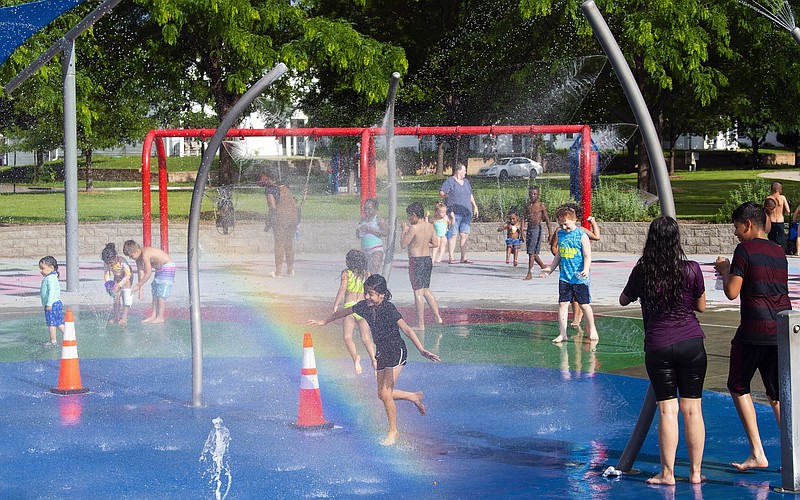 FILE - Children and adults take advantage of the warm weather to cool off at the Trago Spray Park on Friday, June 10, 2022, in Lincoln, Neb.  The fast-changing coronavirus has kicked off summer in the U.S. with lots of infections but relatively few deaths compared to its prior incarnations. COVID-19 is still killing hundreds of Americans each day, but for many people the virus is not nearly as dangerous as it was.  (Kenneth Ferriera/Lincoln Journal Star via AP)