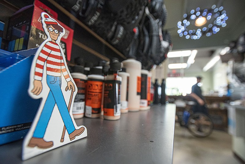 A cardboard Waldo figure stands on a shelf at Phat Tire Bike Shop in Fort Smith. The store was one of 17 local businesses and museums that spent July 1 kicking off the annual Find Waldo Local summer activity, a citywide search in which spotters who locate the hidden figures collect stamps from the participating businesses and exchange them for prizes from host sponsor Bookish: An Indie Shop For Folks Who Read. A drawing for a deluxe set of Waldo books will be held at a celebration July 31 at Bookish when the promotion ends.

(NWA Democrat-Gazette/Hank Layton)