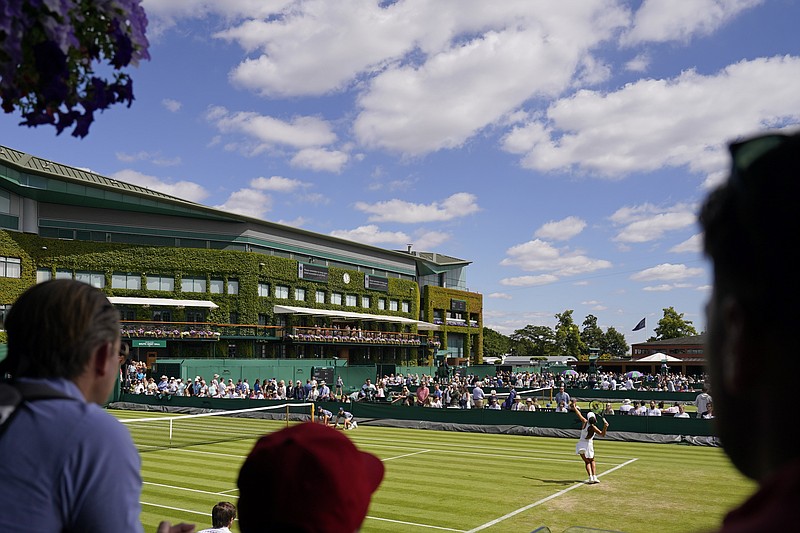 Spectators watch as Italy's Georgia Pedone serves during a girls singles match on day eight of the Wimbledon tennis championships in London Monday. – Photo by Alberto Pezzali of The Associated Press