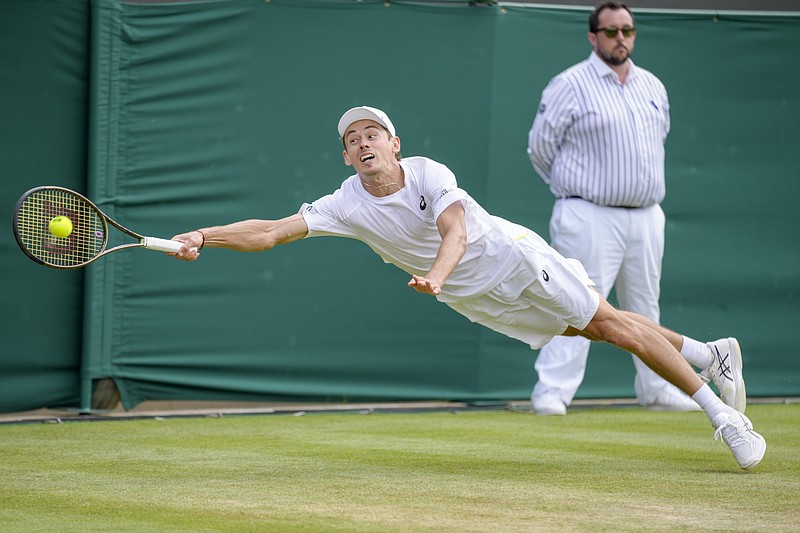 Australia's Alex De Minaur reaches out to return the ball to Chile's Cristian Garin during a men's singles fourth round match on day eight of the Wimbledon tennis championships in London, Monday, July 4, 2022. (AP Photo/Kirsty Wigglesworth)