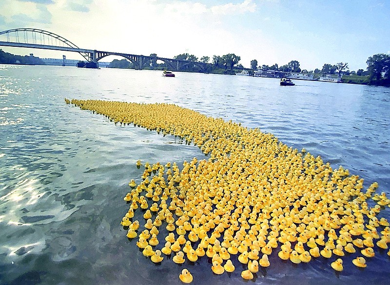 Some of 6,000 yellow bathtub toys that were dumped into the Arkansas River from the top of the Broadway Bridge float east toward the finish line during the American Cancer Society's fundraising Rubber Ducky Regatta on the evening of July 18, 1992.  (Democrat-Gazette file photo/Staton Breidenthal)