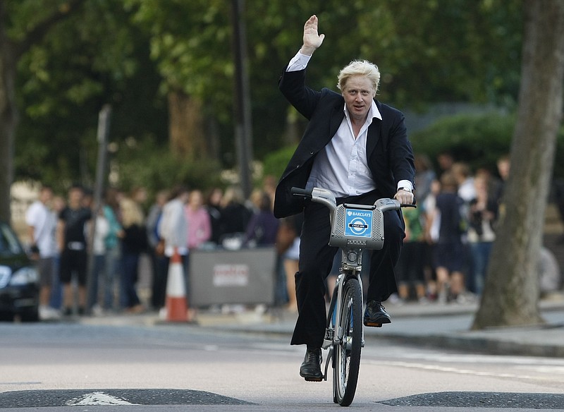 Boris Johnson saluda a la gente el 30 de julio del 2010 cuando, siendo alcalde de Londres, lanzó una iniciativa para promover el uso de bicicletas. (AP Photo/Alastair Grant, File)