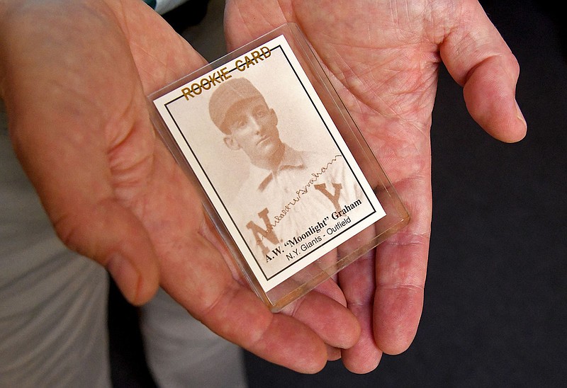 Larry Pitrof, executive director of the Medical Alumni Association of the University of Maryland, holds a reproduction rookie-style card for baseball player and physician Archibald “Moonlight” Graham on June 15, 2022, in Baltimore. The card was made decades after Graham's one game in the major leagues. (Barbara Haddock Taylor/Baltimore Sun/TNS)