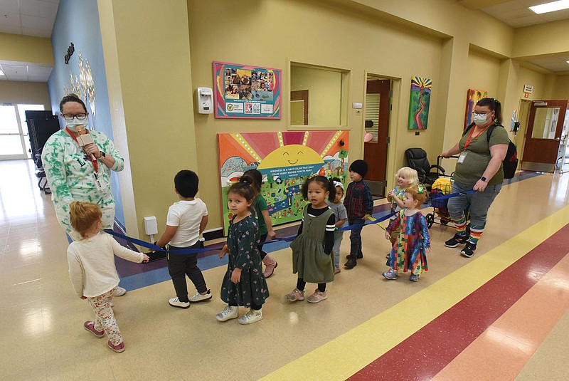 Teachers, including Katie Jennings (left), lead students through a hallway to a play area on Wednesday March 17 2021 at the Benton County Sunshine School and Development Center.
(NWA Demorcrat-Gazette/Flip Putthoff)