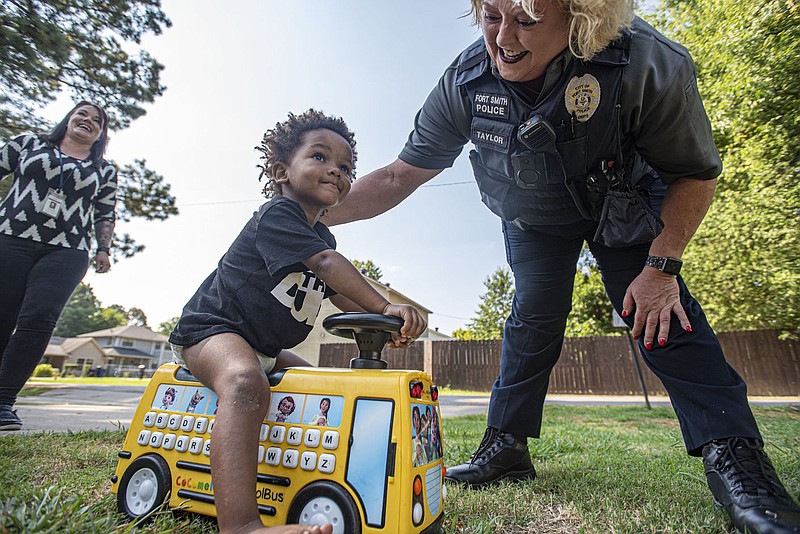 Cheri Taylor (right) and Vicki Loyd with the Fort Smith Police Department’s Crisis Intervention Unit visit with Abraham Hodge, 2, on Friday, July 15, 2022, outside his family’s home in Fort Smith. While many cities in Northwest Arkansas and the River Valley saw violent crime surge in 2020 and continue in 2021, violent crime dropped significantly in Fort Smith during that time in large part because of efforts related to crisis intervention and de-escalation, according to the department. Visit nwaonline.com/220717Daily/ for today's photo gallery.
(NWA Democrat-Gazette/Hank Layton)